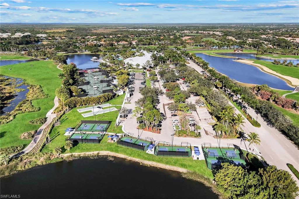 Multiple pickleball courts, tennis courts, and a large parking area surrounded by mature trees