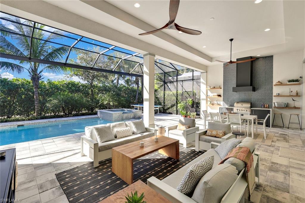 Expansive outdoor living area featuring a screened-in pool and spa