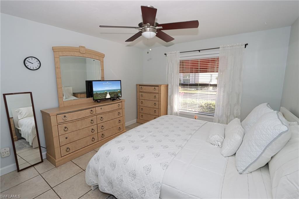 Tiled bedroom featuring ceiling fan