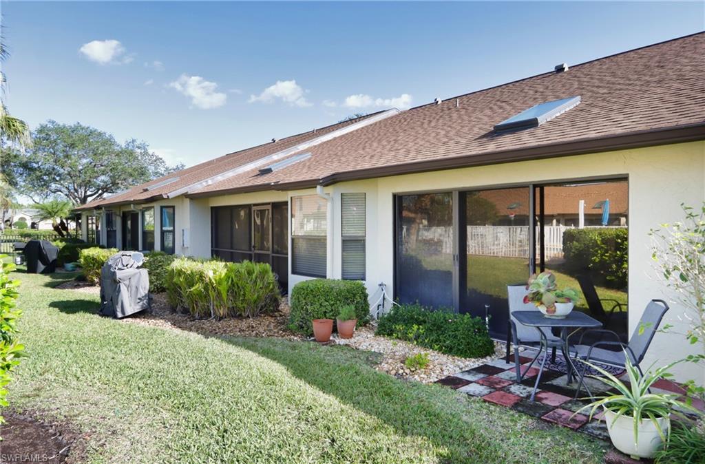 Back of property with a lawn and a patio