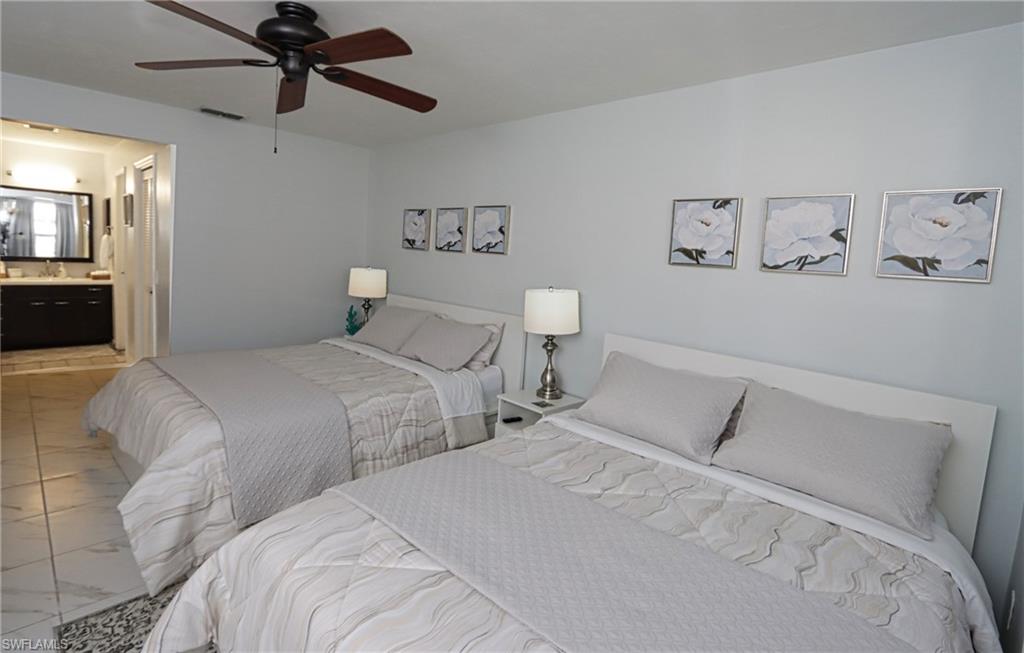 Bedroom featuring ceiling fan, connected bathroom, and sink