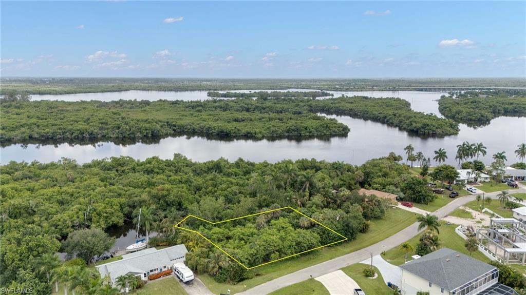 Expansive undeveloped lot featuring lush natural foliage and direct water frontage