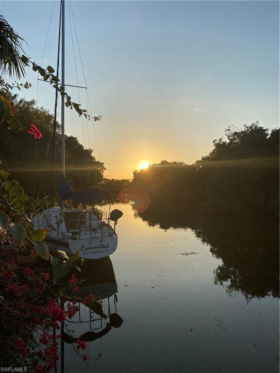 Waterfront setting featuring a docked sailboat and lush natural surroundings