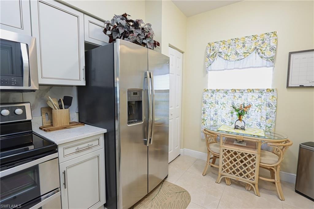 Kitchen featuring appliances with stainless steel finishes and light tile flooring