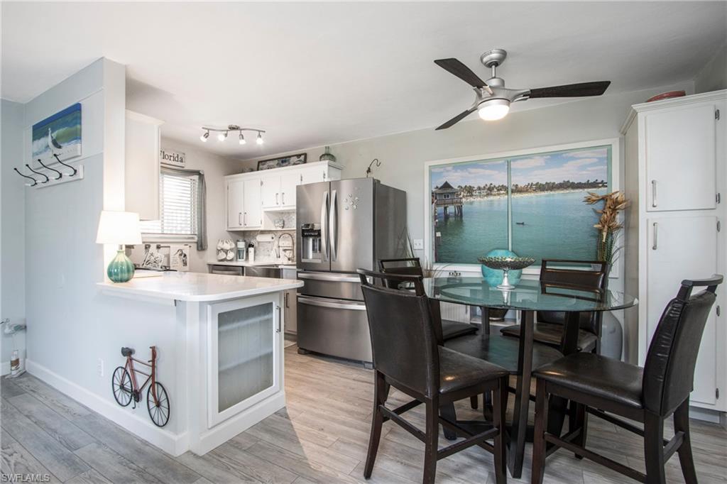Kitchen featuring sink, kitchen peninsula, white cabinetry, stainless steel refrigerator with ice dispenser, and light hardwood / wood-style floors