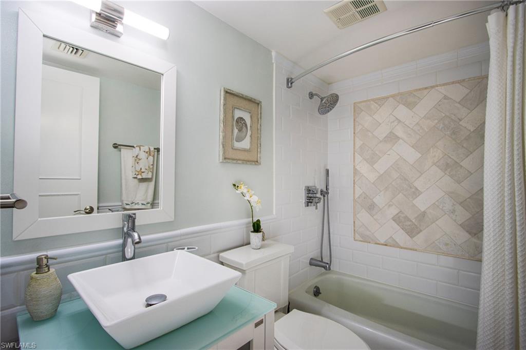 Full bathroom with shower / tub combo with curtain, vanity, and toilet