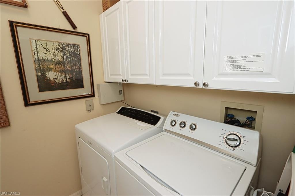 Laundry area featuring cabinet space and washer and clothes dryer