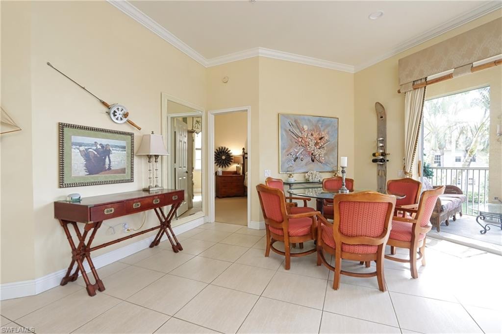 Dining room with crown molding and light tile patterned flooring