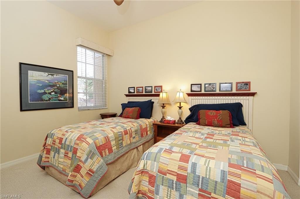 Carpeted bedroom with baseboards and a ceiling fan