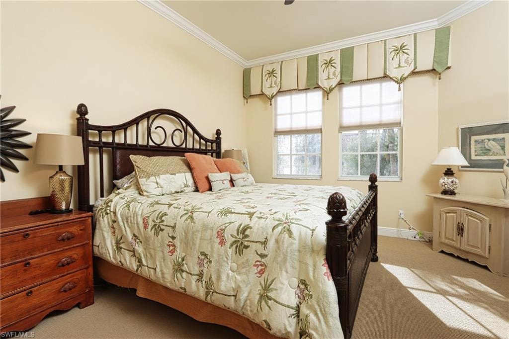 Bedroom featuring crown molding, light carpet, and a ceiling fan