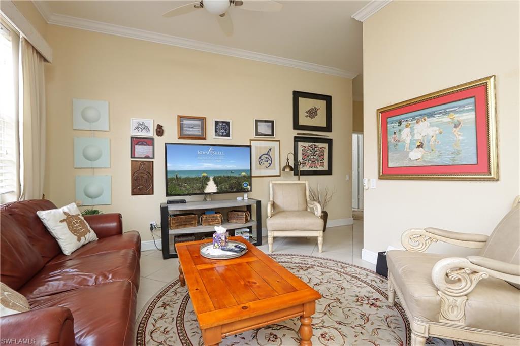 Tiled living area featuring crown molding and a ceiling fan