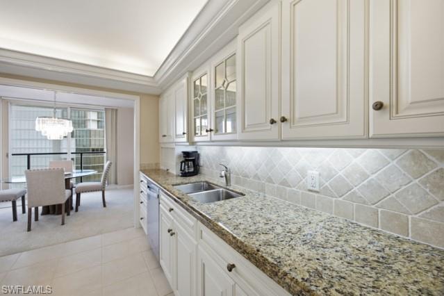 Kitchen featuring light-toned cabinetry, granite countertops, and a diagonally laid tile backsplash
