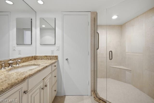 Bathroom vanity featuring a light-toned stone countertop with an undermount sink and a brushed nickel faucet