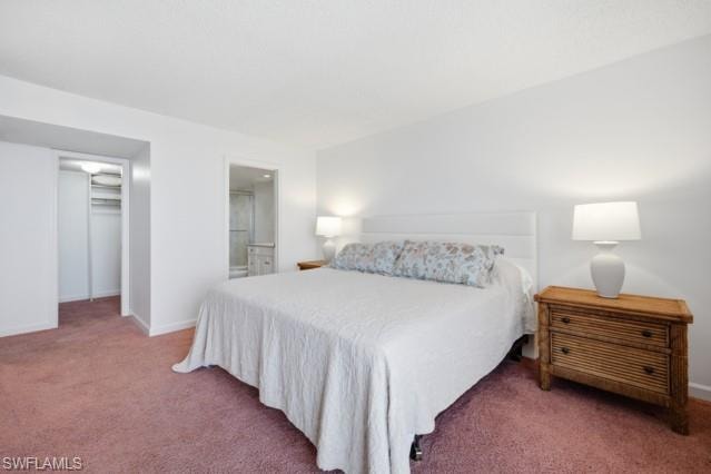Spacious bedroom featuring plush carpeting, a closet with bi-fold doors, and an en-suite bathroom entry