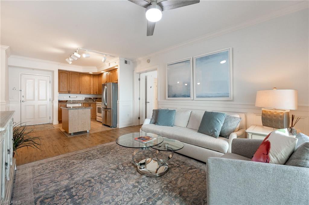 Living room with crown molding, track lighting, light hardwood / wood-style floors, and ceiling fan