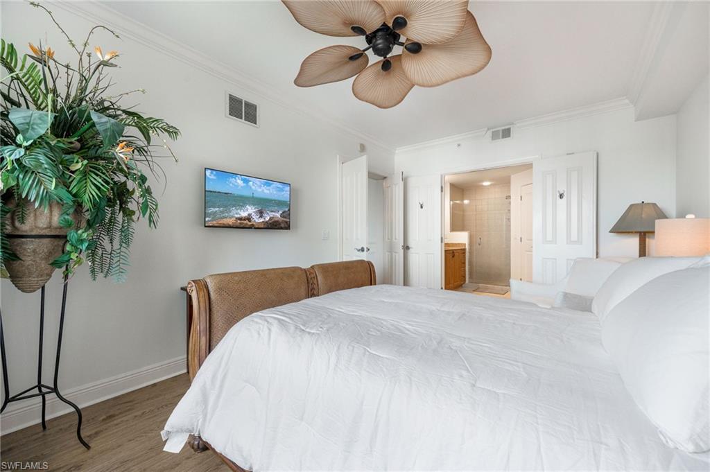 Bedroom featuring crown molding, ceiling fan, wood-type flooring, and connected bathroom