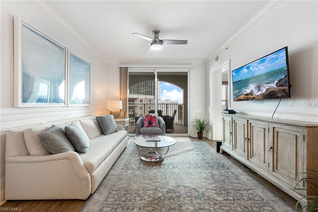 Living room featuring ceiling fan, ornamental molding, and dark hardwood / wood-style flooring
