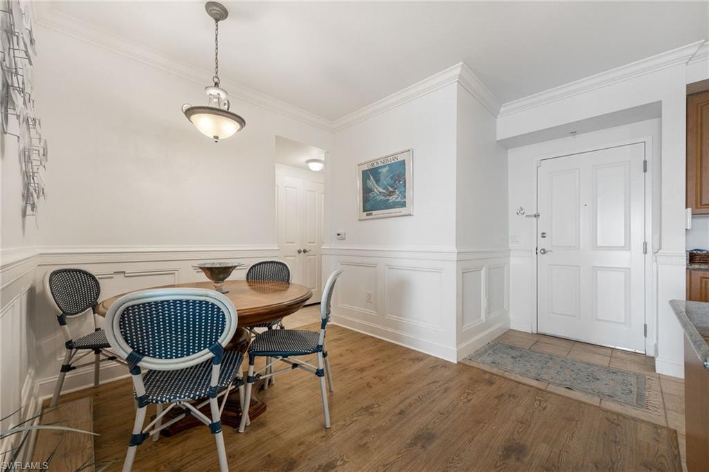 Dining space featuring wood-type flooring and ornamental molding