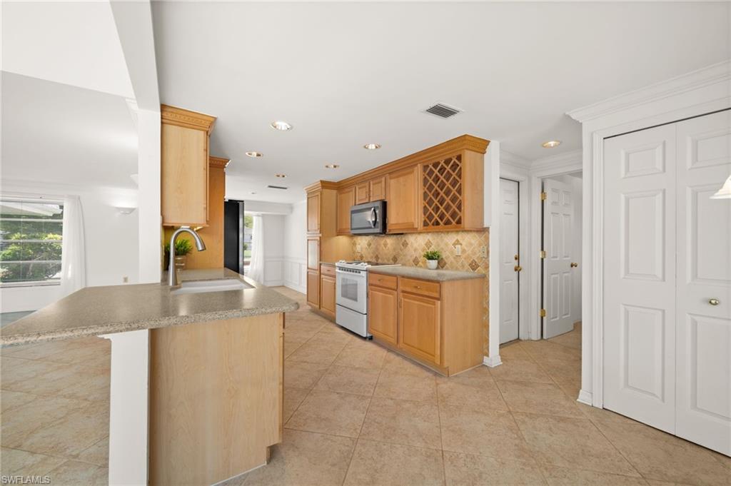 Passthrough kitchen with  breakfast bar and crown molding