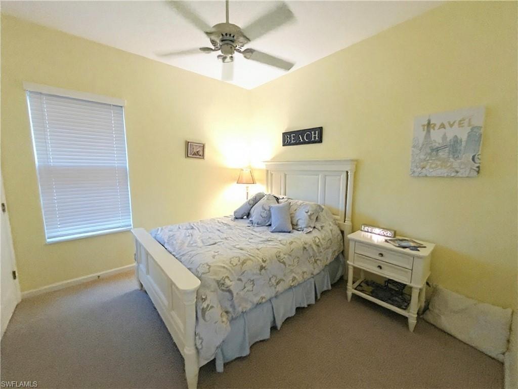 Carpeted room featuring a ceiling fan, a single window with horizontal blinds, and warm-toned wall finishes