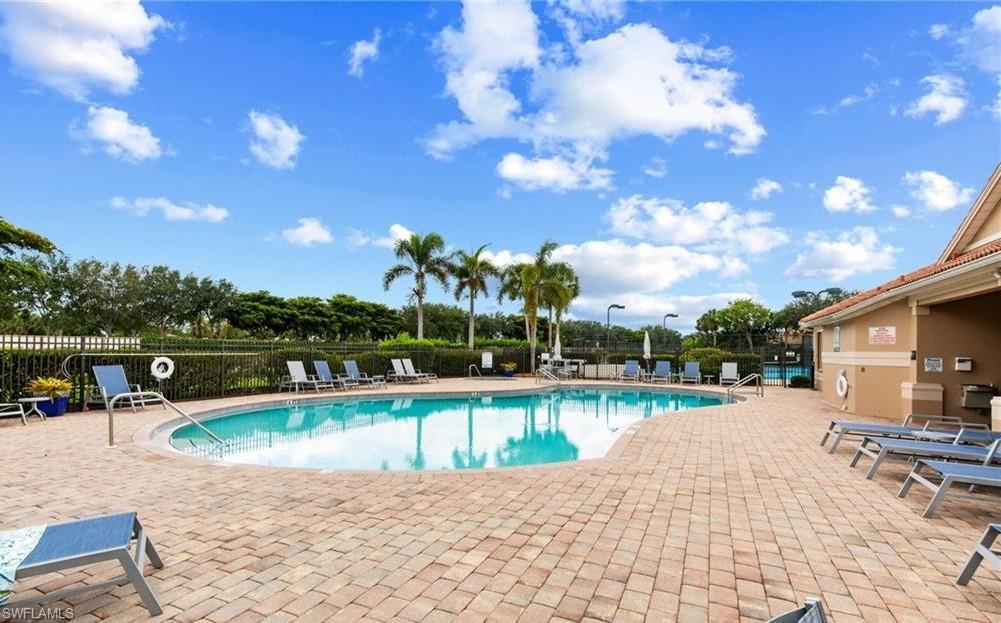 Community swimming pool with a freeform design, surrounded by a paver deck
