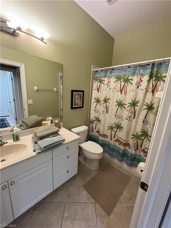 Bathroom featuring a single vanity with stone-look countertop, white cabinetry, and a full-size mirror