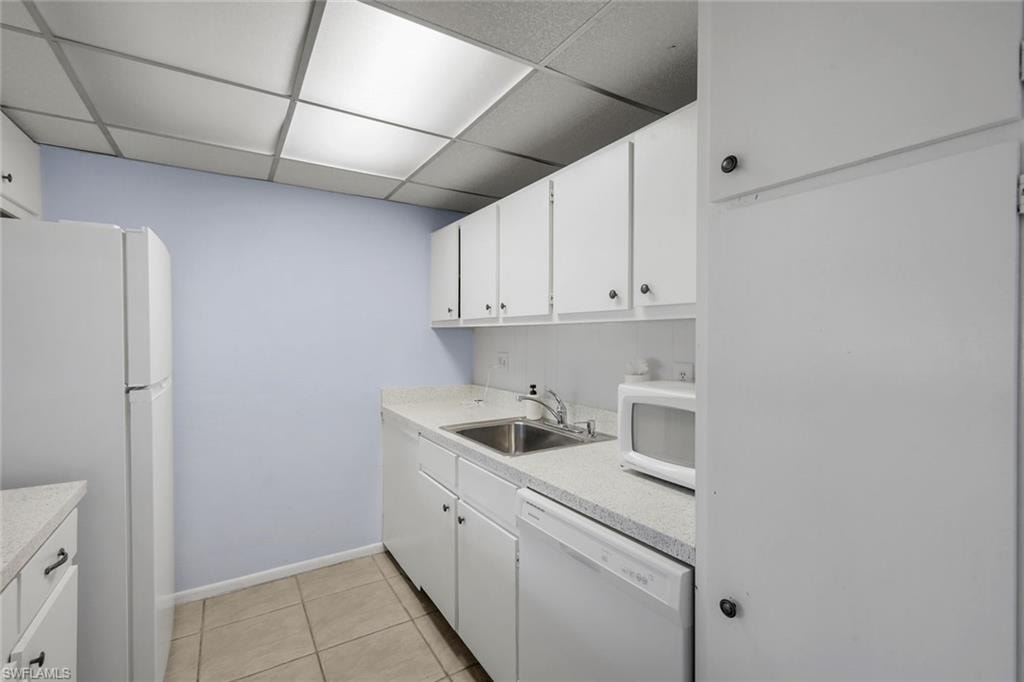 Kitchen featuring white cabinetry, light countertops, and tile flooring