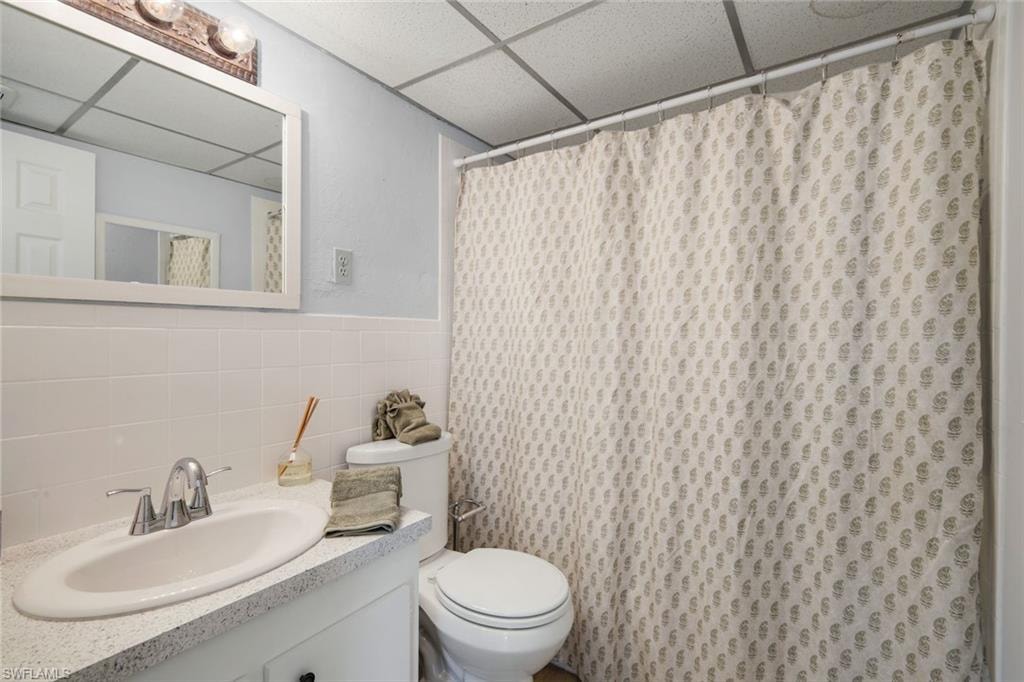 Bathroom featuring a single vanity with an integrated sink, chrome faucet, and a light-toned countertop