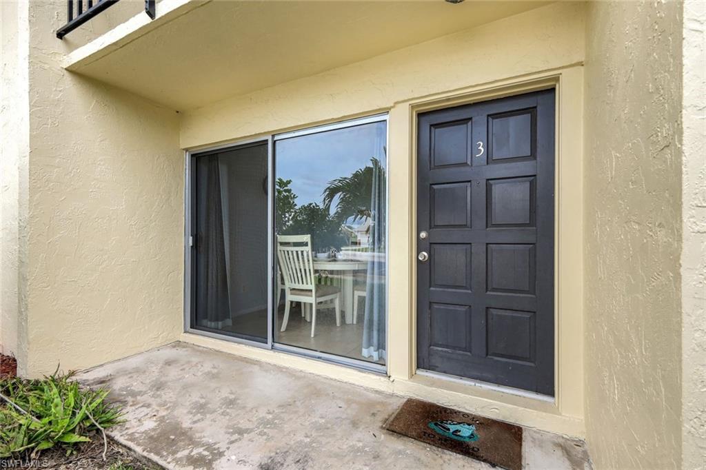 Entry featuring a dark paneled door with number 3, adjacent to a sliding glass door with a screen