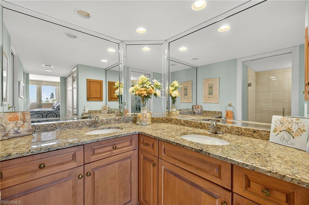 Ensuite bathroom with double vanity, recessed lighting, and a tile shower