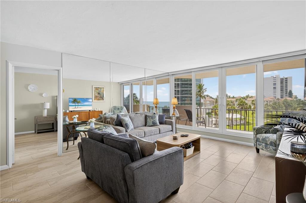 Living room with light wood-style floors and floor to ceiling windows