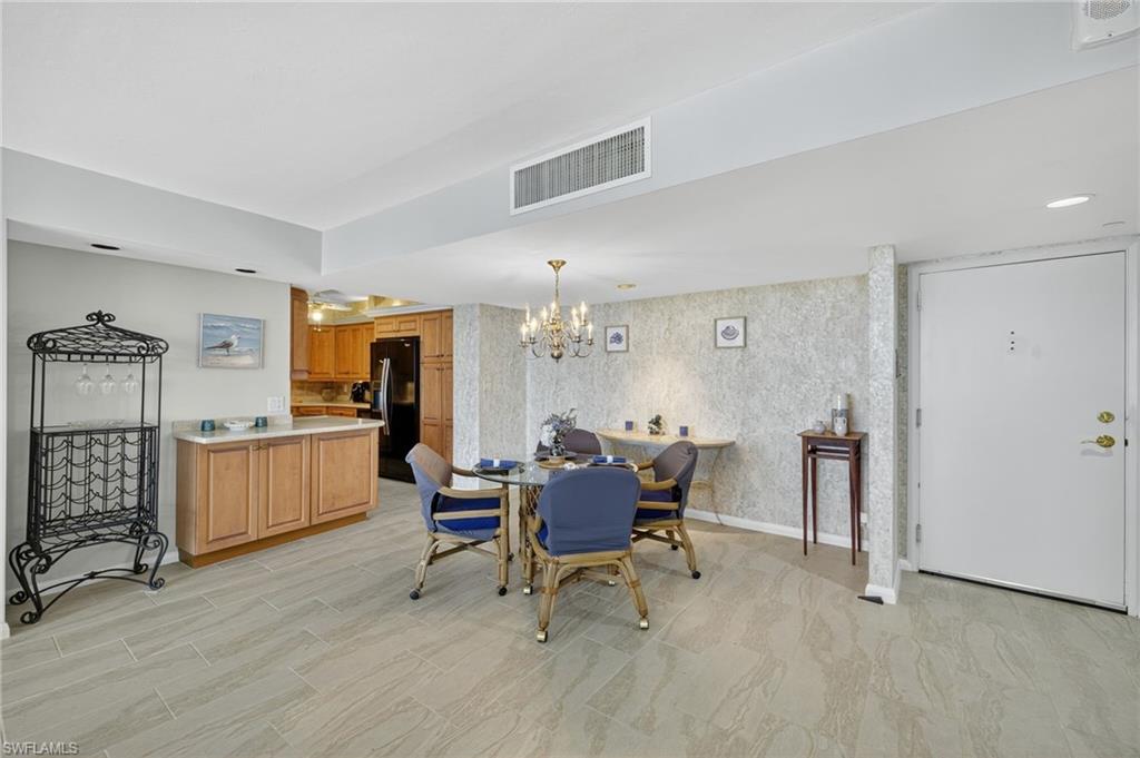 Dining space featuring wallpapered walls and a chandelier