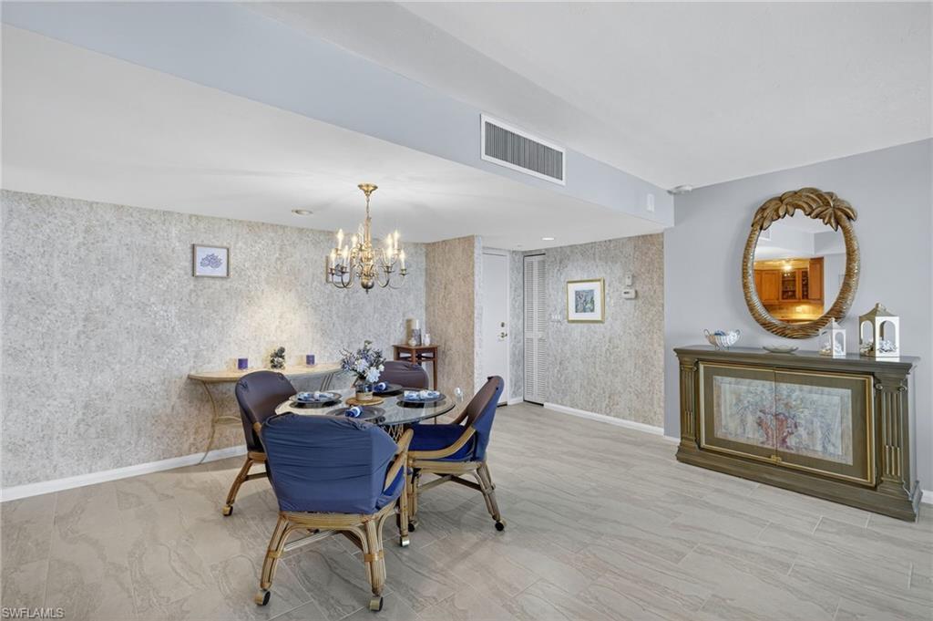Dining space featuring a chandelier and wallpapered walls