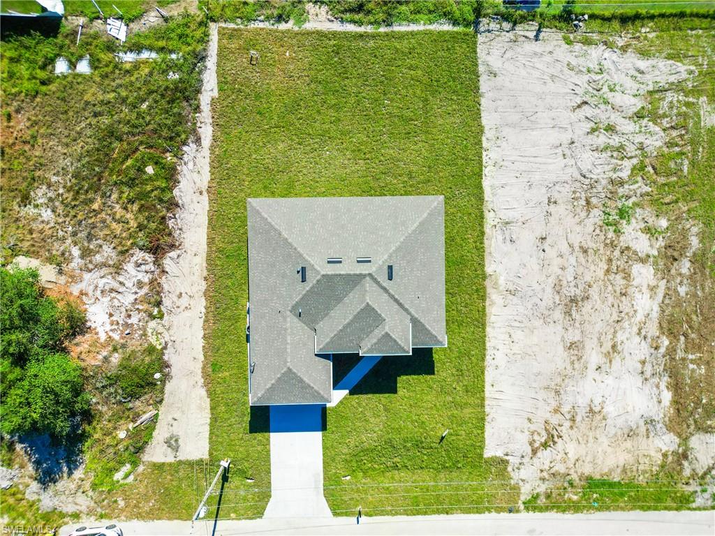 New construction residence featuring a shingle roof and a concrete driveway