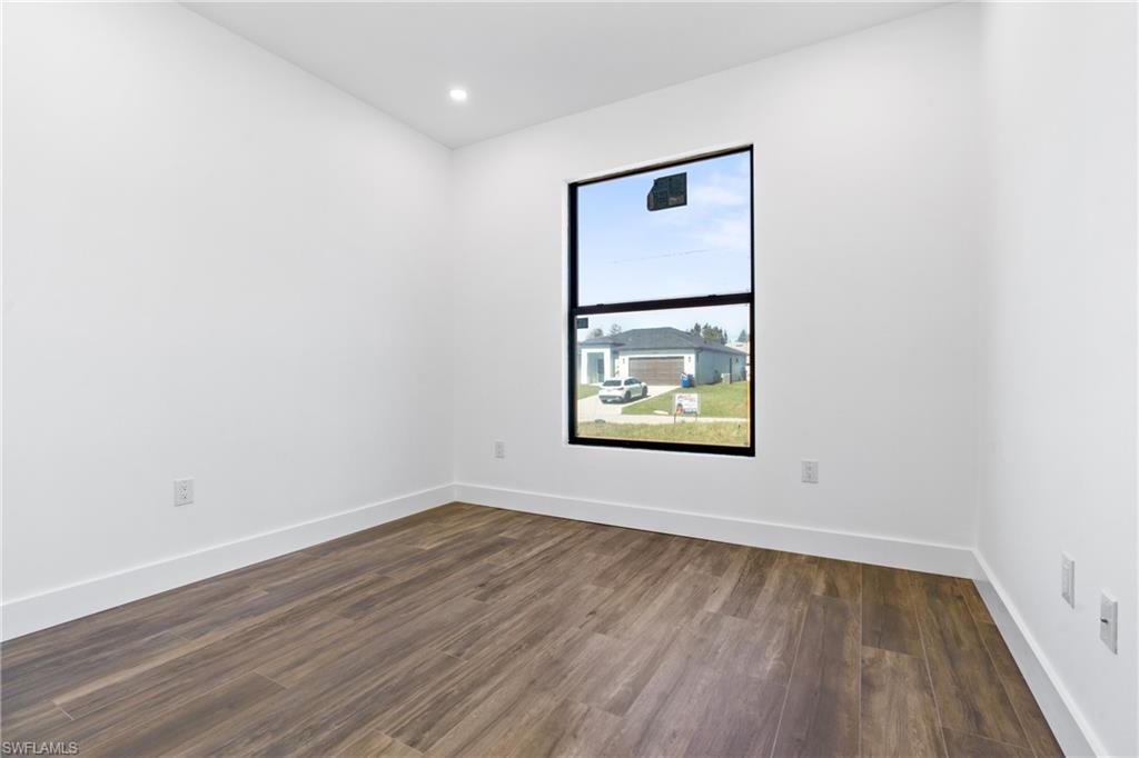 Wood-finish flooring with white baseboards and light-toned walls