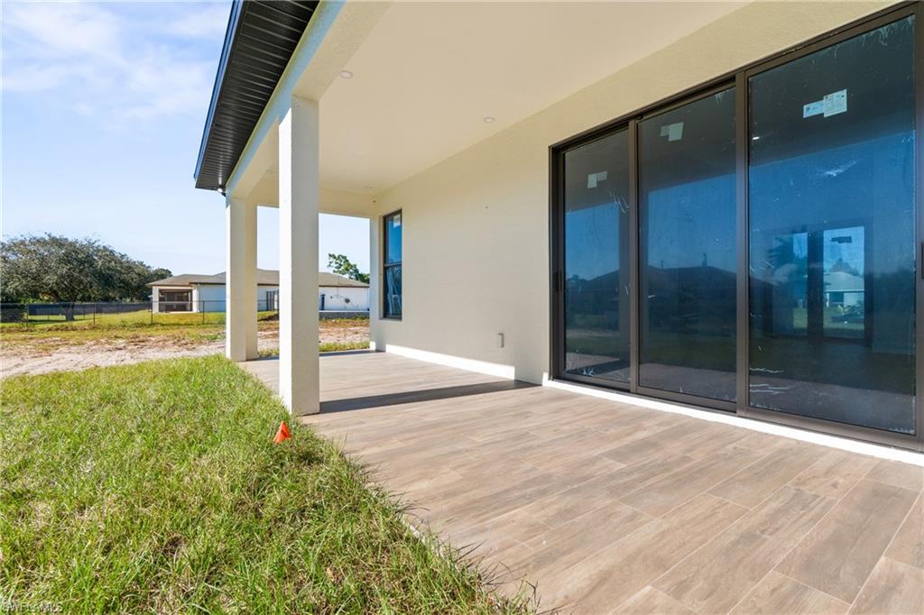 Expansive covered patio featuring wood-finish tile flooring and recessed lighting