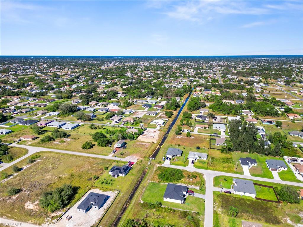 Expansive aerial capturing a suburban landscape with numerous single-story properties under a clear sky