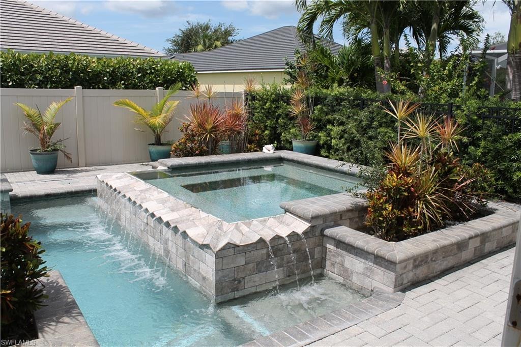 Inviting aquatic feature with a tiered spa, integrated waterfall, and stone-tiled accent wall