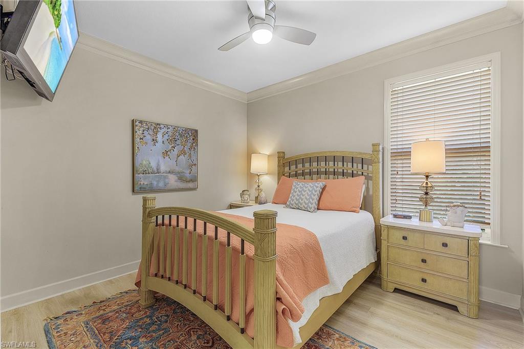 Room with crown molding, a ceiling fan, and wood-finish flooring