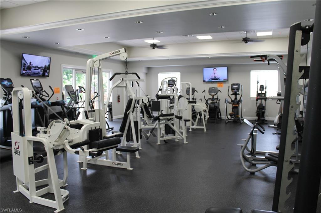 Spacious fitness center featuring a variety of cardio and strength training equipment, durable rubber flooring, recessed lighting, and ceiling fans