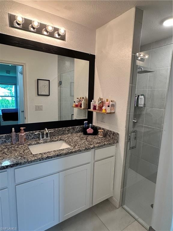 Bathroom featuring a white vanity with a granite-style countertop, undermount sink, and chrome faucet