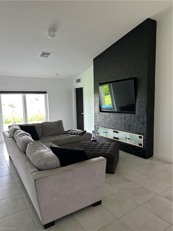 Living area featuring large format tile flooring and a distinctive black textured accent wall