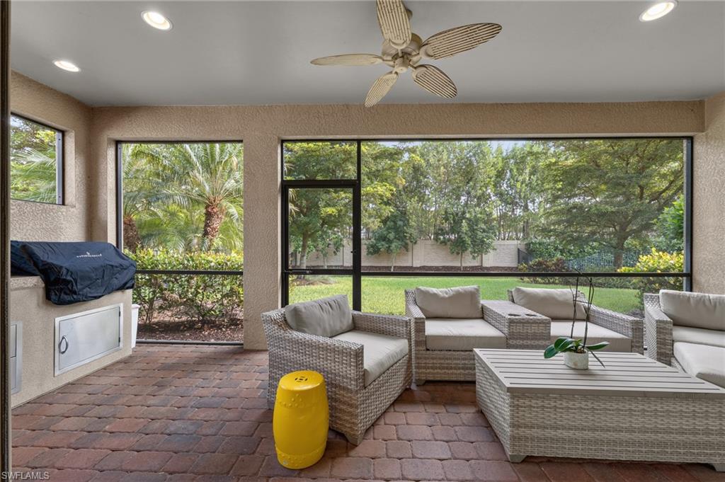 Screened outdoor patio featuring brick pavers and a built-in grill station with stainless steel access doors