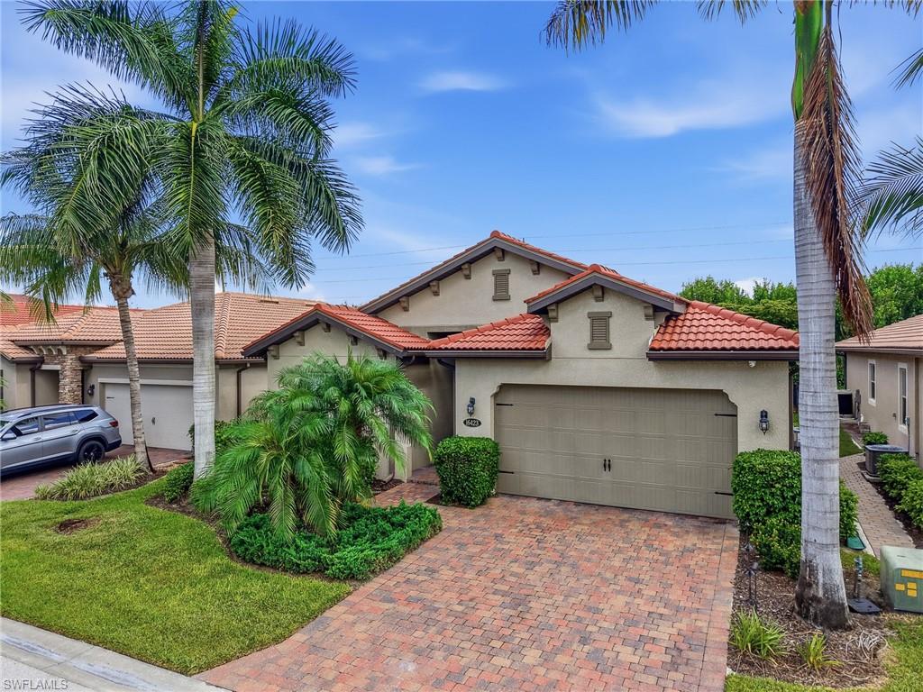 Mediterranean-inspired exterior featuring a terracotta tile roof, stucco finish, and an integrated two-car garage