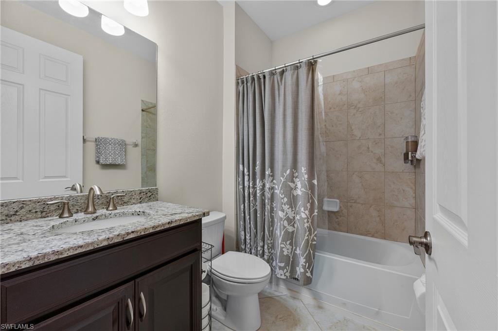 Bathroom featuring a dark wood-finish vanity with a light granite countertop, undermount sink, and brushed nickel fixtures