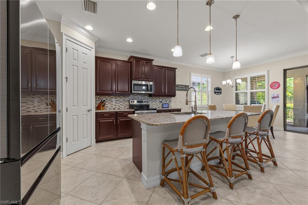 Kitchen featuring a large central island with a granite countertop, pendant lighting, and tile flooring