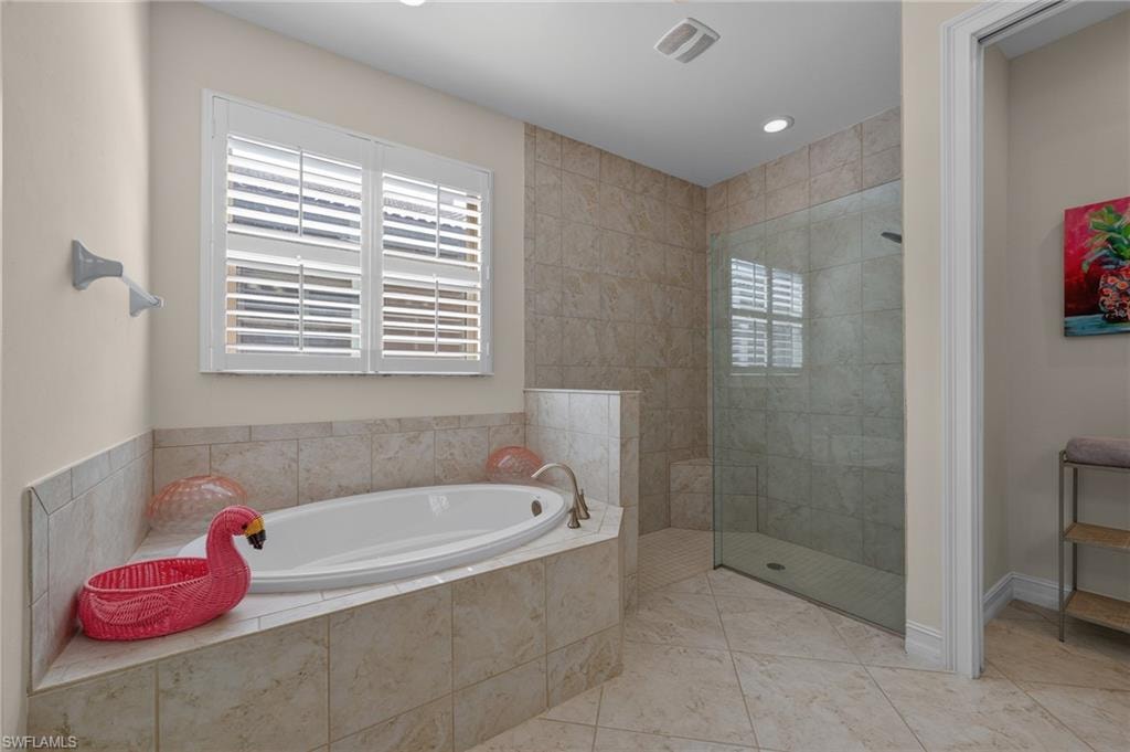 Soaking tub with a tiled surround, plantation shutters, and a separate glass-enclosed shower featuring a tiled bench