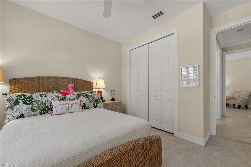 Bedroom featuring tile flooring, neutral wall tones, and white bi-fold closet doors