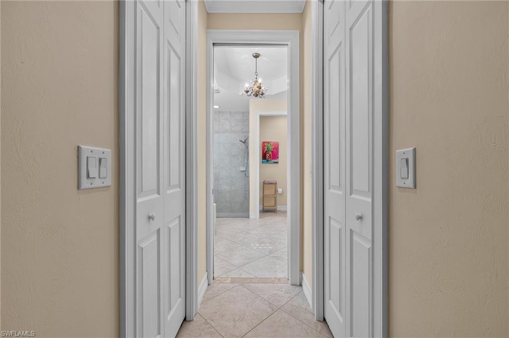 Hallway featuring neutral wall paint, white bi-fold closet doors, and recessed lighting