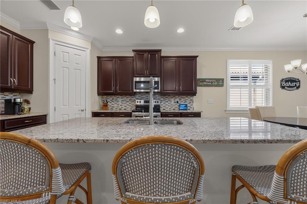 Expansive kitchen island featuring a granite countertop and an undermount stainless steel sink